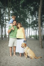 Family smiling together on wooded beach