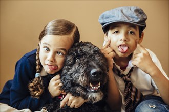 Mixed race children making faces with dog