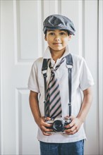 Mixed race boy wearing camera on strap