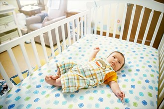 Caucasian baby boy laying in crib