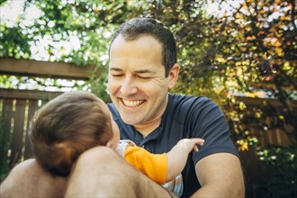 Caucasian father holding baby boy outdoors