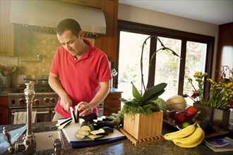 Caucasian man chopping vegetables in kitchen