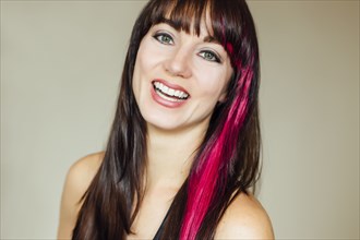 Smiling Caucasian woman with pink dye in hair
