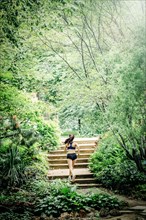 Caucasian woman running on staircase in park