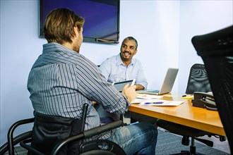 Businessmen talking at conference table in office