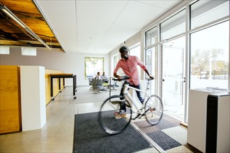 Blurred view of businessman pushing bicycle into office