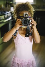 Mixed race girl photographing with camera
