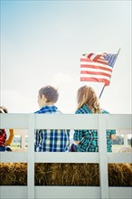 Caucasian children waving American flag on hay ride