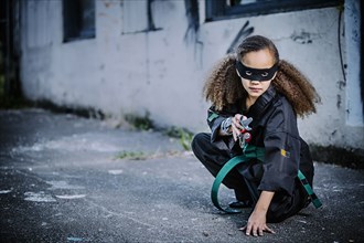 Mixed race girl in martial arts uniform and mask