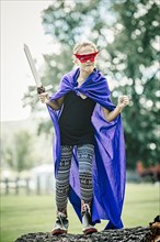 Caucasian girl wearing costume and playing with sword