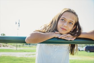 Caucasian girl leaning on farm fence