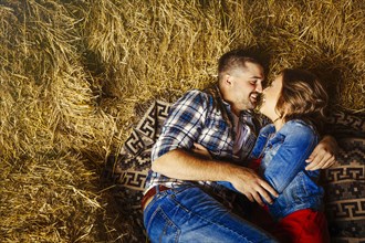 Caucasian couple kissing in haystacks