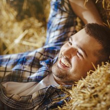 Caucasian man laying on haystacks