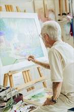 Caucasian artist painting in studio