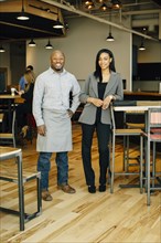 Waiter and businesswoman smiling in cafe
