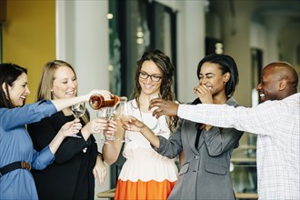 Business people celebrating with wine in office