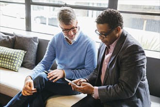 Businessmen using cell phone in office