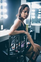 Black woman sitting at vanity mirror