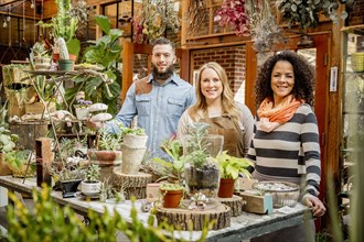 Employee and customers smiling in plant nursery