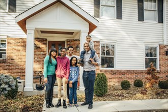 Black family smiling outside house