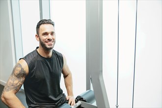 Man using exercise machine in gymnasium