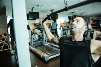 Man using exercise machine in gymnasium