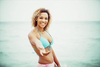 Mixed race teenager wearing bikini on beach
