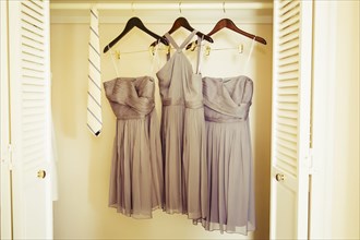 Bridesmaid dresses hanging in closet