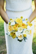 Caucasian bride holding bouquet outdoors