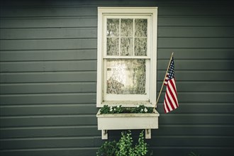 American flag in window box outside house