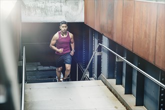 Indian man jogging on city steps