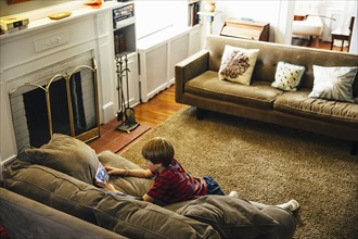 Caucasian boy using cell phone in living room