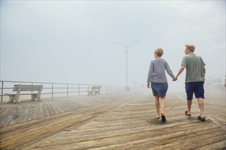 Couple holding hands on wooden boardwalk