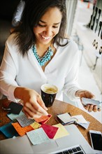 Businesswoman examining fabric samples in cafe