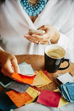 Businesswoman examining fabric samples in cafe