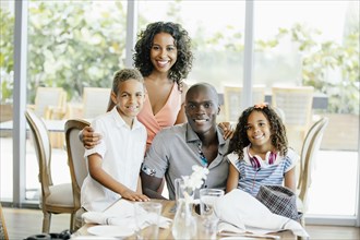 Family smiling at restaurant table