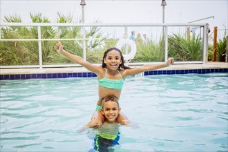 Mixed race children playing in swimming pool