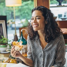 Mixed race woman eating in cafe