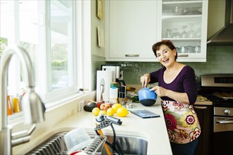 Caucasian woman cooking in kitchen