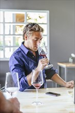 Caucasian man smelling wine in restaurant