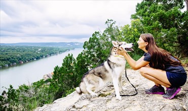 Caucasian woman petting dog outdoors
