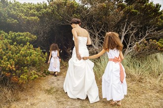 Bride and flower girls walking on dirt path