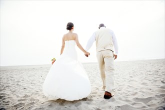 Newlywed couple walking on beach