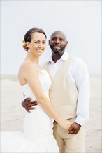 Newlywed couple hugging on beach