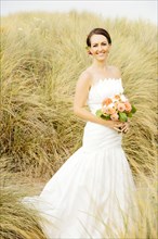 Caucasian bride standing on beach