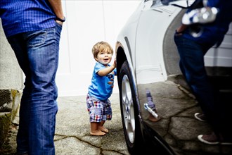 Father and baby son washing car