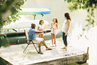 Family standing on dock in lake