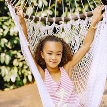 Mixed race girl sitting in hammock