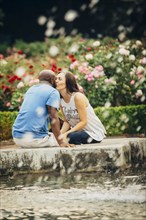 Couple kissing at fountain in garden