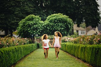 Mixed race sisters walking in garden